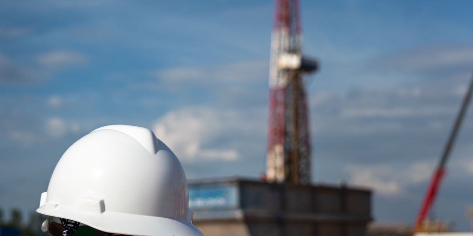 Schutzhelm auf einer Baustelle mit Kran im Hintergrund